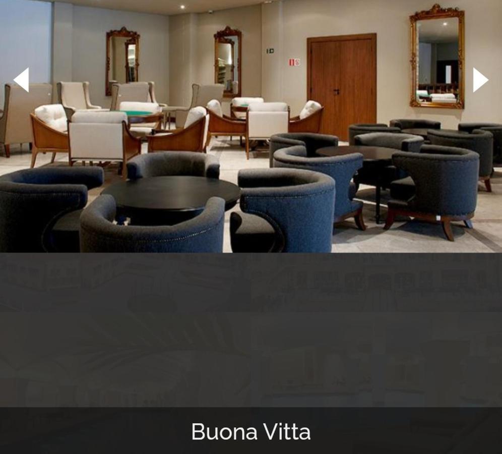Buona Vitta Gramado Resort & Spa By Gramado Parks Exterior foto The photo shows a modern, elegantly designed lounge or waiting area. It features several circular seating arrangements with dark blue armchairs surrounding black tables. In the background, there are light-colored lounge chairs and a wooden door leadi