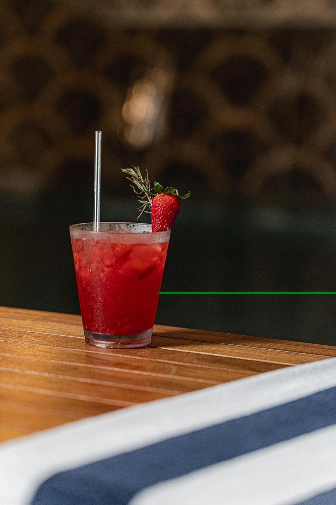 Buona Vitta Gramado Resort & Spa By Gramado Parks Exterior foto The photo shows a refreshing cocktail served in a transparent glass. The drink is vibrant red, suggesting it may be made with strawberries or a similar fruit. It features a straw and a garnish of a fresh strawberry on the rim of the glass, along with